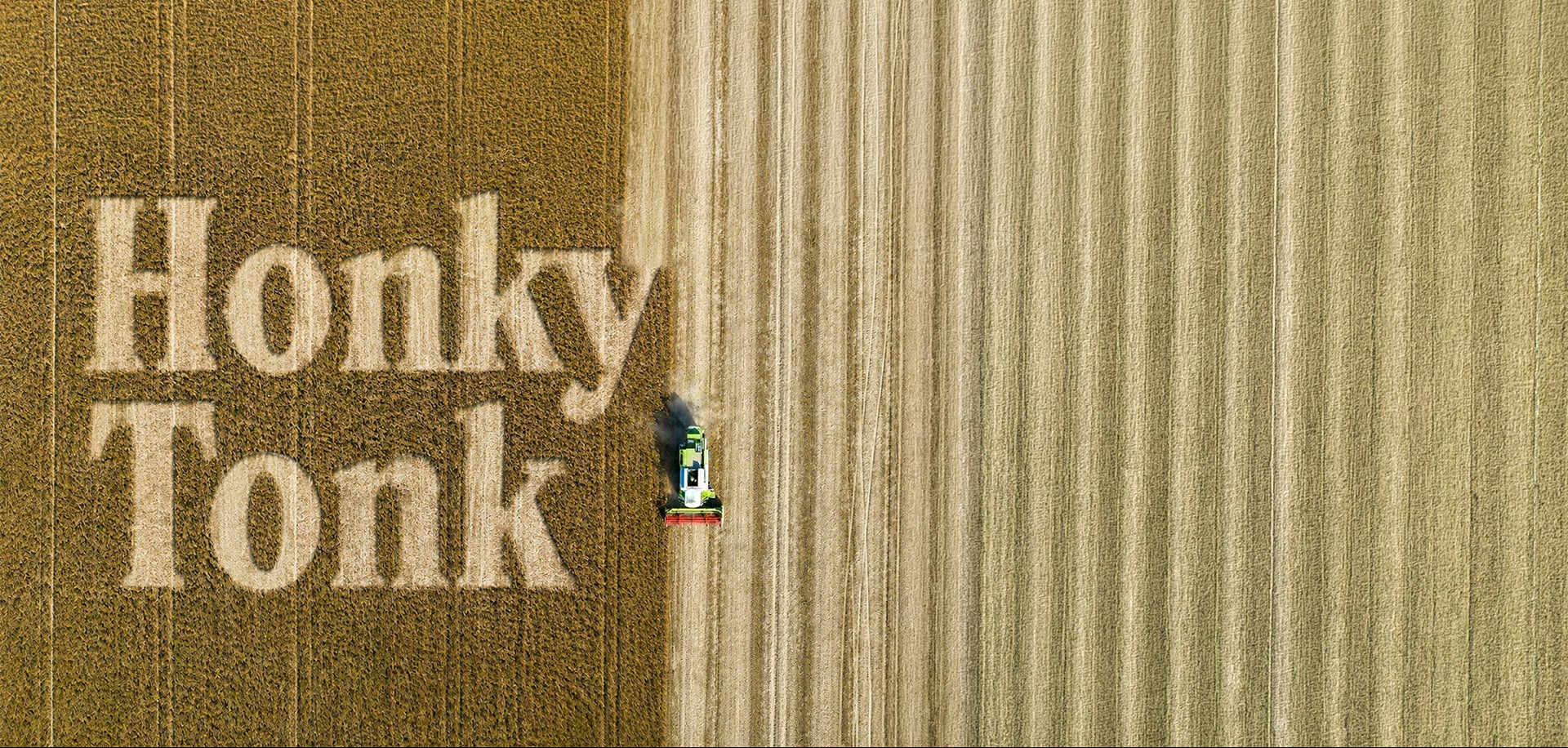 Aerial view of a tractor in a field with 'Honky Tonk' harvested out of the crop.